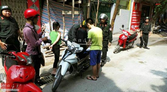 图为河内机动警察在街头纠治未戴头盔的青年，小巷子也去抓。