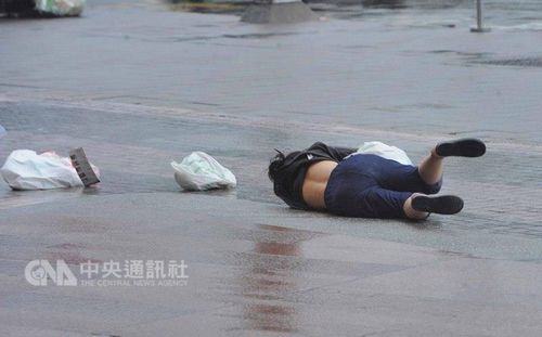  台风“鲇鱼”侵袭台湾，9月27日上午台北市已出现间歇的风雨，路上民众被强风吹倒在地。台湾“中央社”记者王飞华摄