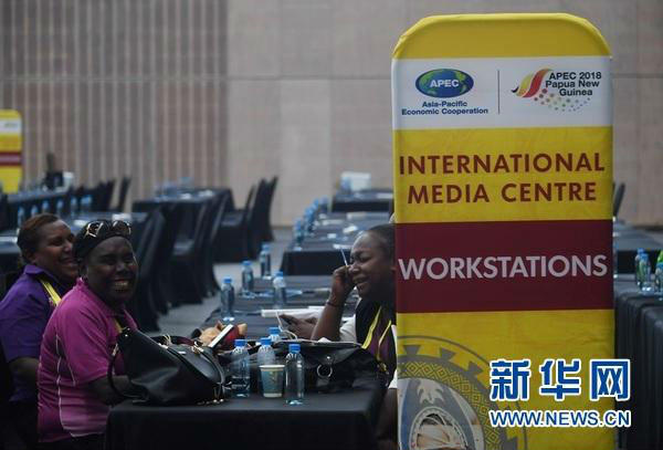 11月11日，在位于巴新莫尔兹比港的APEC新闻中心，工作人员面带笑容。（新华社）