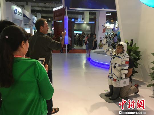 6月8日，第二十届中国北京国际科技产业博览会展览会在京开幕。图为中国航天科技展示区，中外观众合影留念。 杜燕 摄