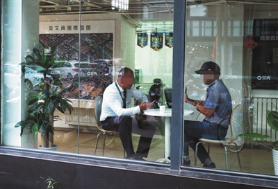  8月20日，广渠路一家房产中介的工作人员正在和客户商谈。新京报记者 彭子洋 摄